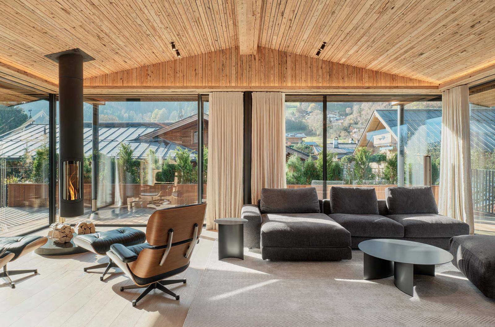 Geräumiges Wohnzimmer mit Holzbalkendecke, gemütlicher Sitzecke und freistehendem Kamin.