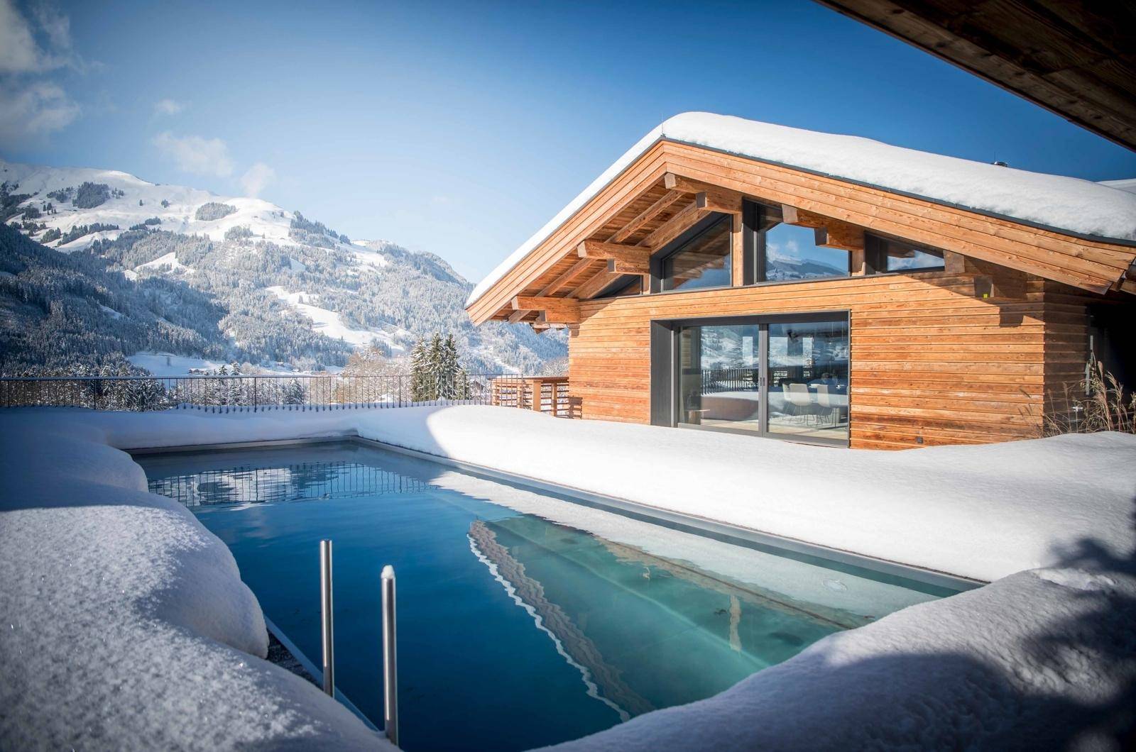 Beheizter Außenpool in winterlicher Umgebung mit Panoramablick auf die Berge.