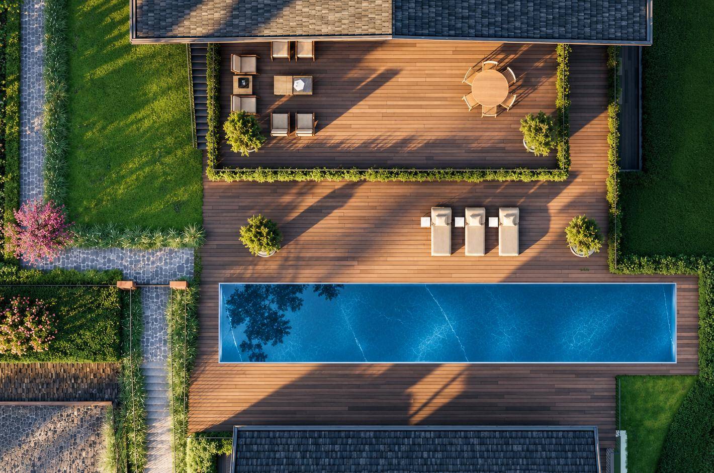 Ansicht von oben auf den langen Pool, die Holzterrasse und die möblierten Außenbereiche.