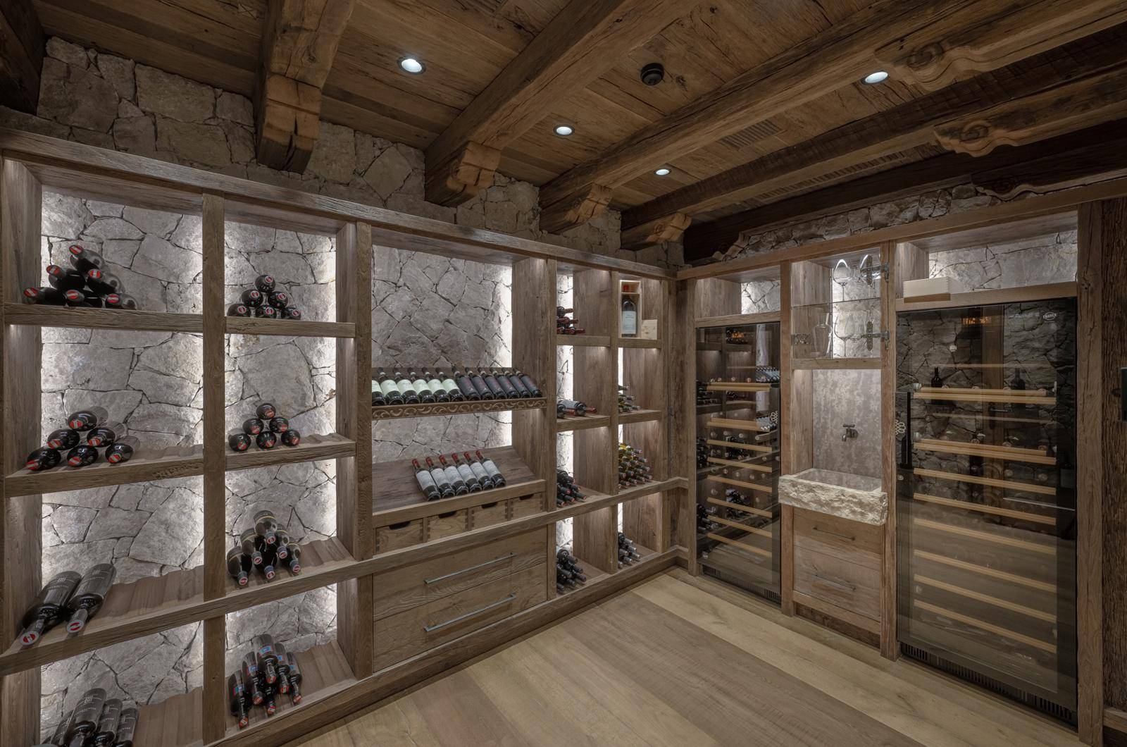 Exklusiver Weinkeller mit beleuchteten Holzregalen und Steinwänden für die Weinlagerung.