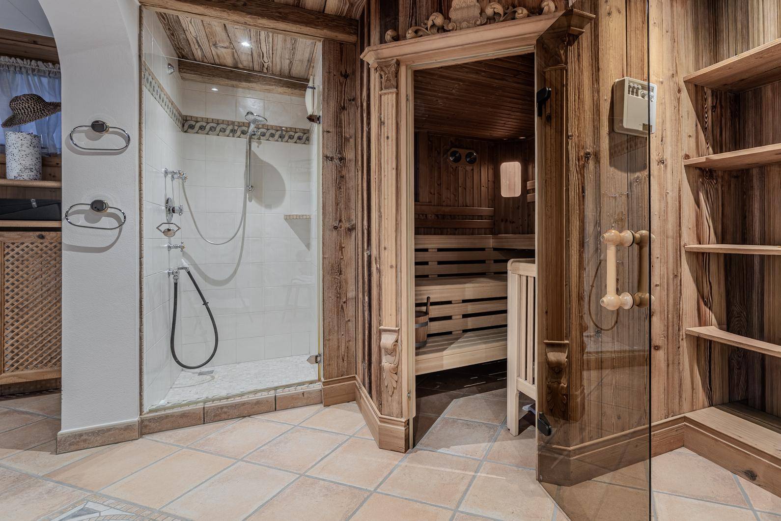 Privater Wellnessbereich mit holzvertäfelter Sauna und angrenzender Duschkabine.