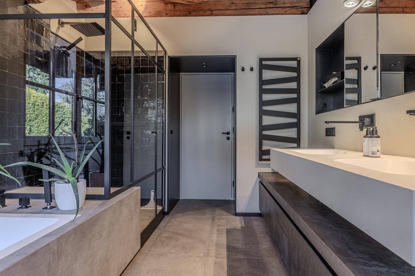 Modernes Badezimmer mit Doppelwaschbecken, großer begehbarer Dusche und beheiztem Handtuchhalter.