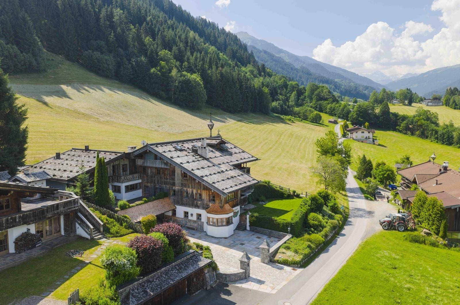 Eingangsbereich eines charmanten Chalets mit gepflegter Auffahrt und umgebender Berglandschaft.