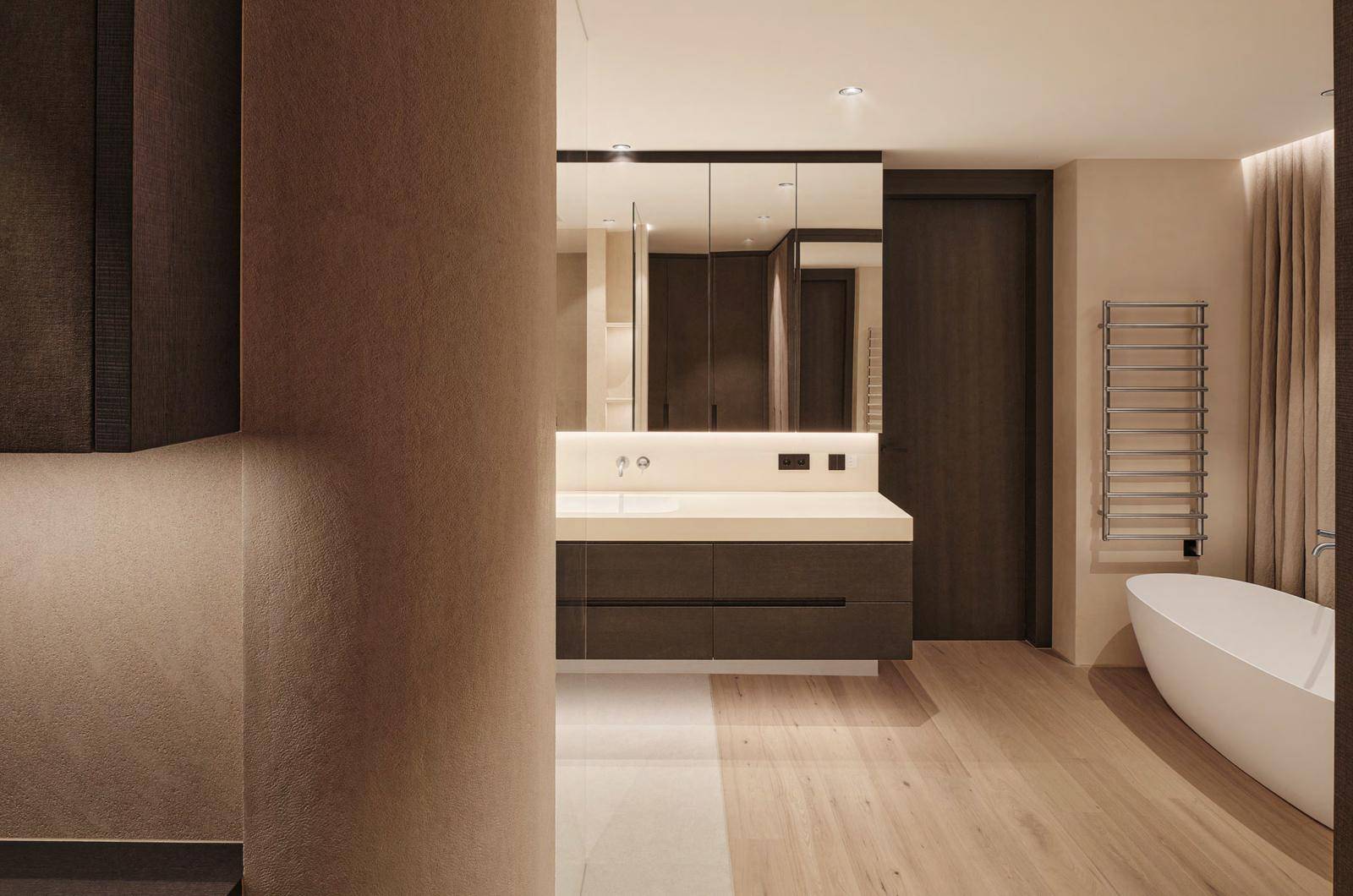 Modernes Badezimmer mit Doppelwaschbecken, freistehender Badewanne und beheiztem Handtuchhalter.