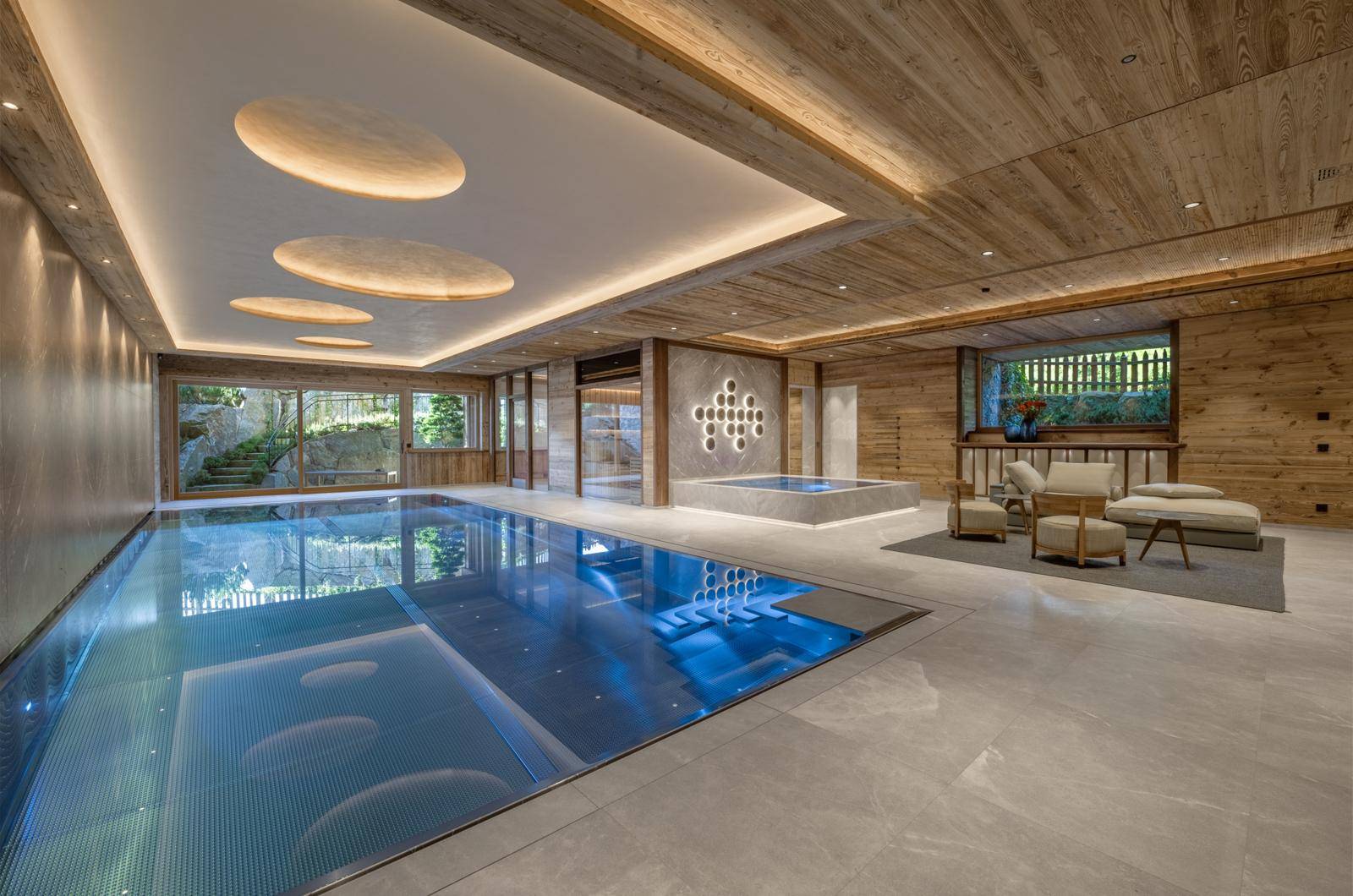 Luxuriöser Innenpoolbereich mit Holzverkleidung, Whirlpool und Entspannungszone.