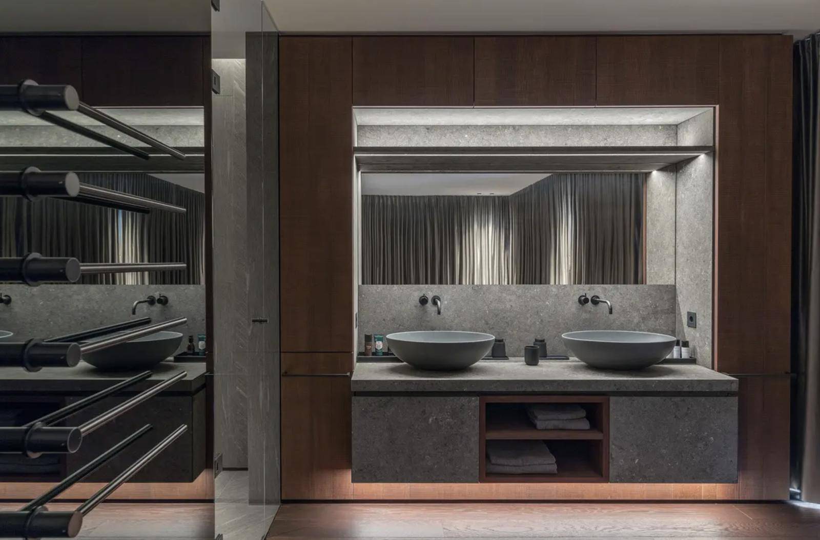 Modernes Badezimmer mit Doppelwaschbecken, Steinwaschtisch und eleganten Holzverkleidungen.