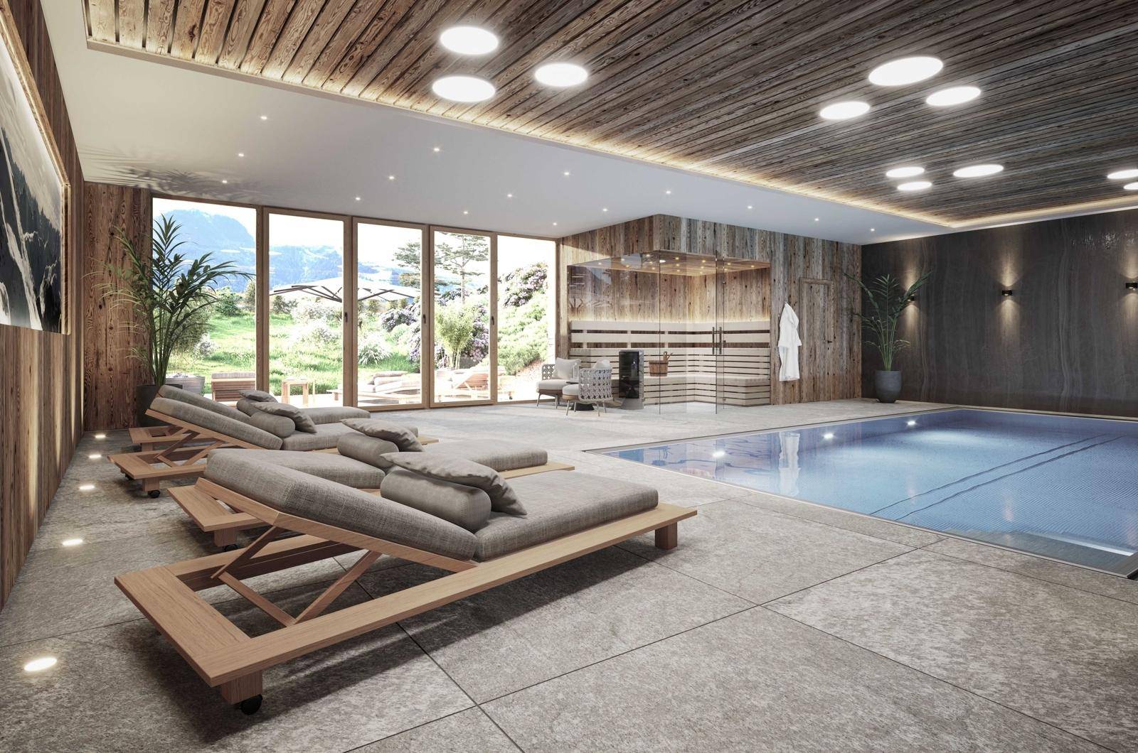 Exklusiver Wellnessbereich mit Innenpool, Sauna und Liegeflächen mit Bergblick.