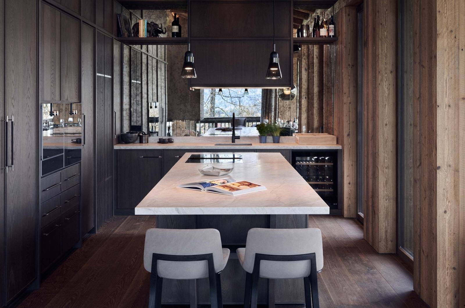 Stilvolle Küche mit dunklen Holzschränken, heller Arbeitsplatte und integriertem Weinkühlschrank.