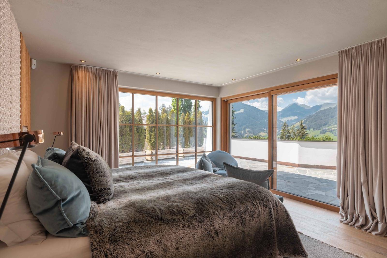 Helles Schlafzimmer mit großen Fenstern, Bergblick und direktem Zugang zur Terrasse.