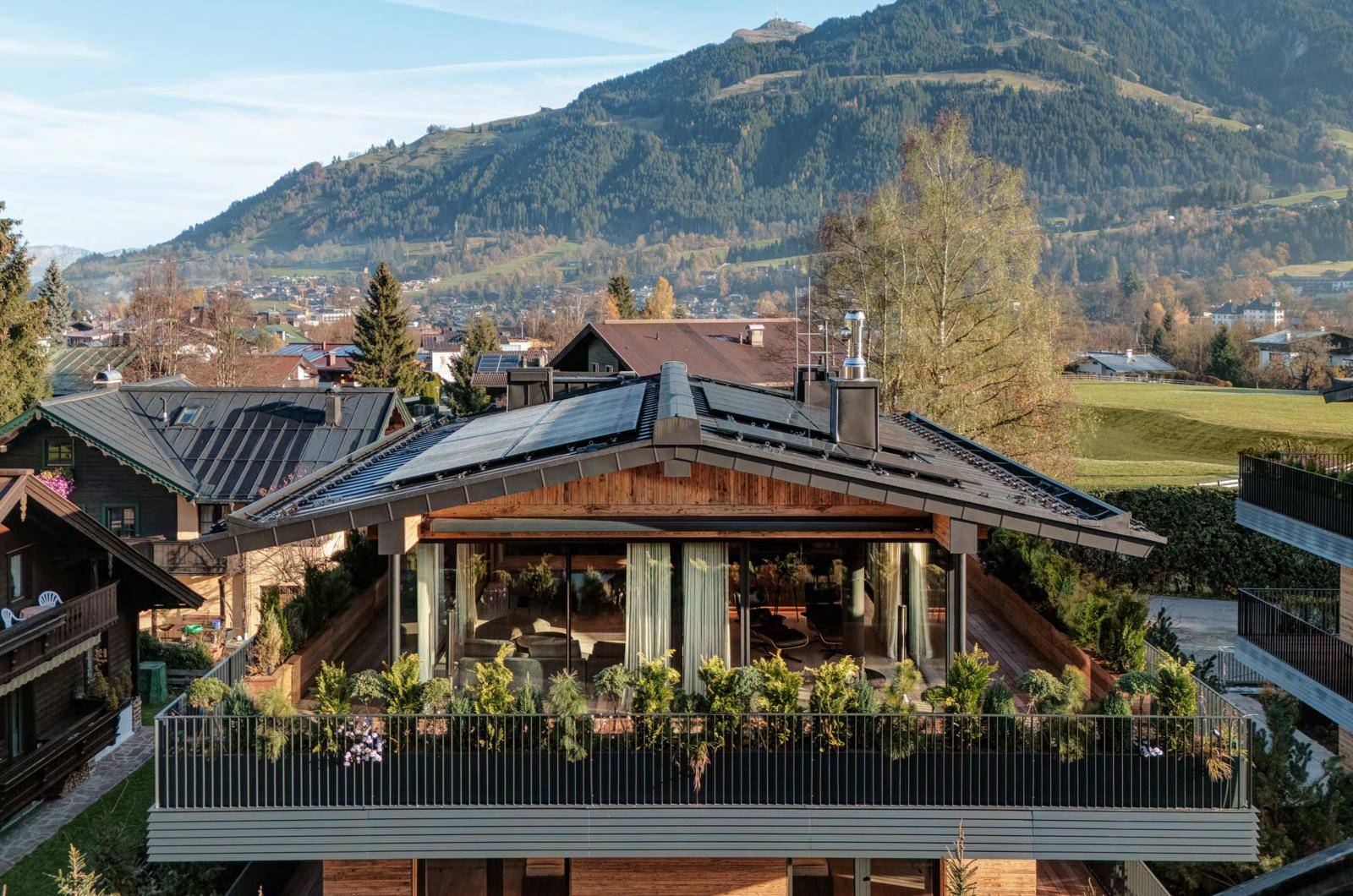 Große Dachterrasse mit Bepflanzung und weitem Blick auf die umliegende Berglandschaft.
