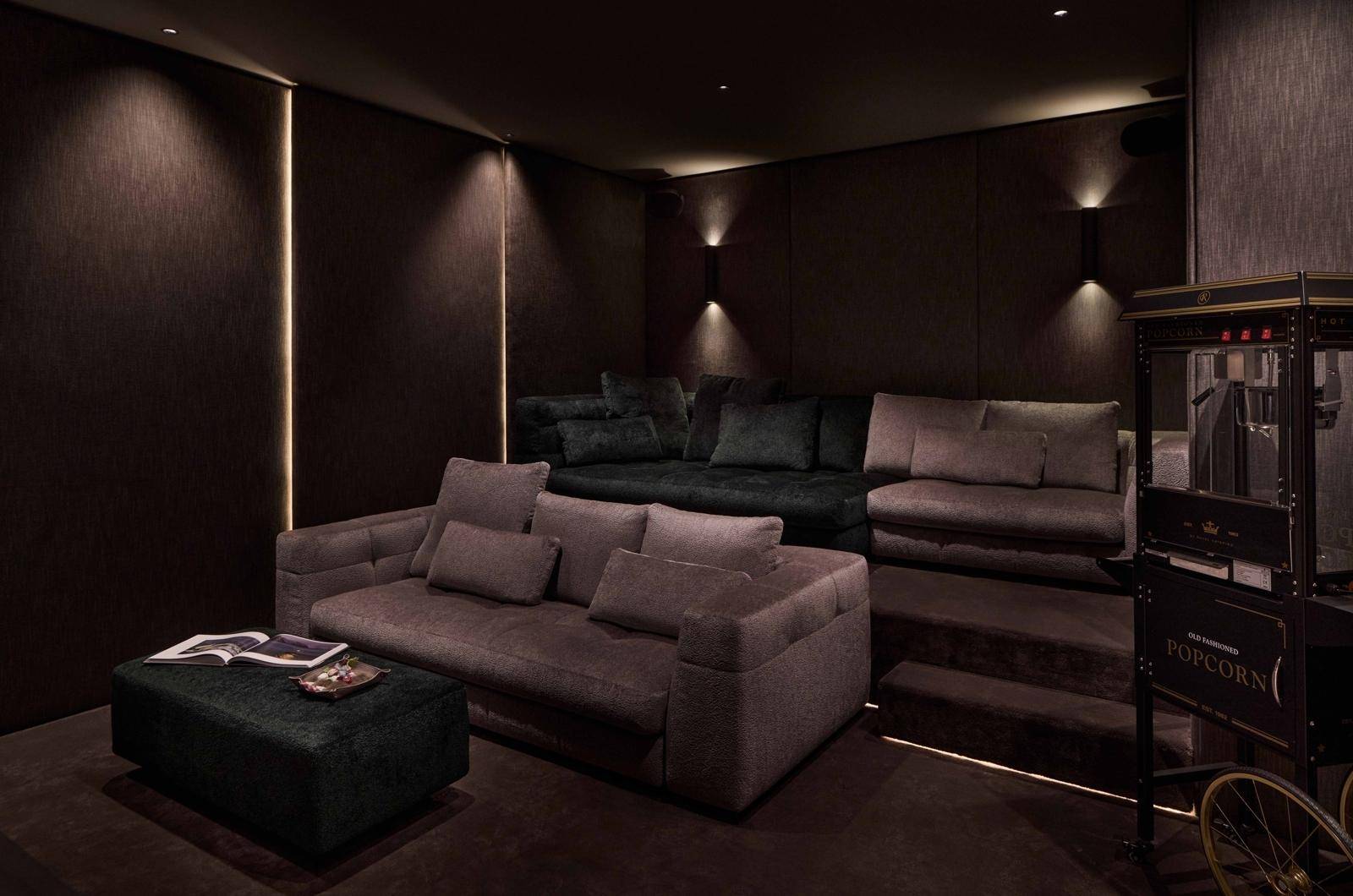 Gemütlicher Medienraum mit gestuften Sofas und Popcornmaschine für Filmabende.