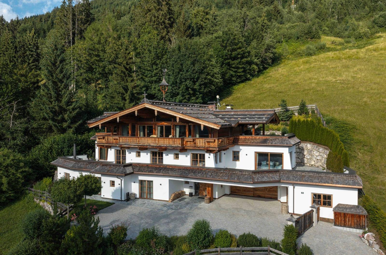 Luxuriöses Chalet in alpiner Landschaft mit weitläufigem Grundstück, Carport und Bergblick.