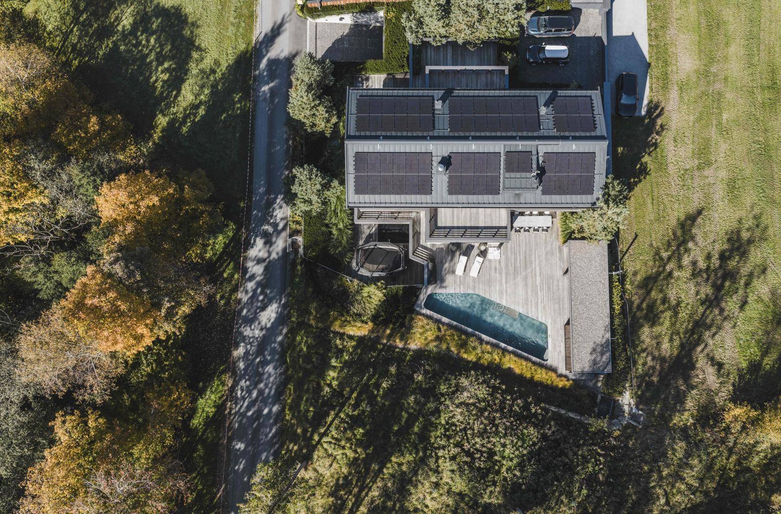 Luftaufnahme des Anwesens mit Solaranlage, Außenpool, Trampolin und weitläufigen Grünflächen.