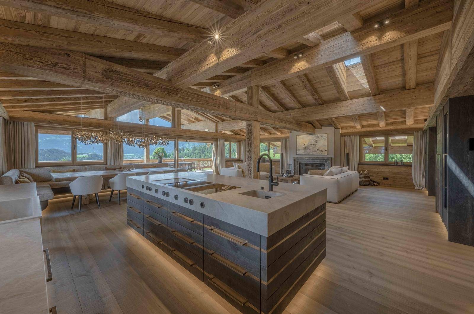 Offener Wohn- und Essbereich mit moderner Küche, Holzbalkendecke und Panoramablick.