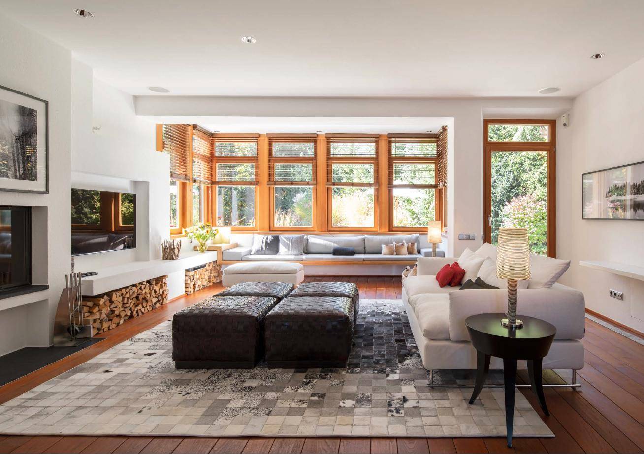 Geräumiges Wohnzimmer mit bequemen Sofas, Holzboden und einem modernen Kaminbereich.