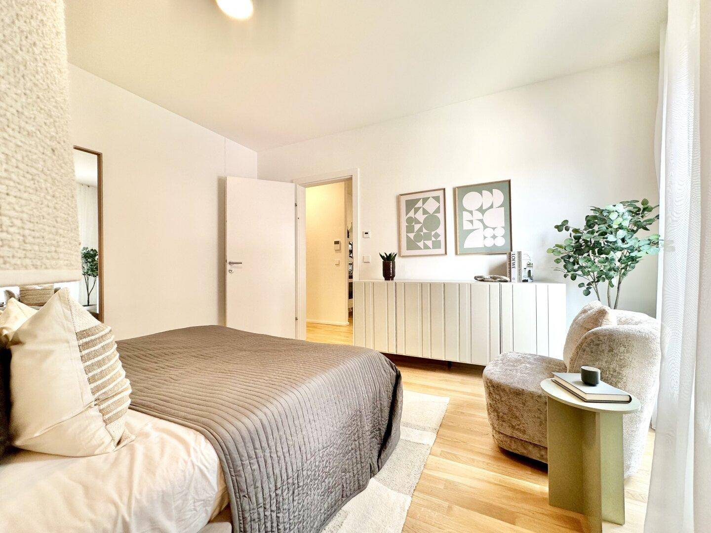 Helles Schlafzimmer mit Holzboden, modernem Bett und stilvollen Möbeln, die eine ruhige Atmosphäre schaffen.