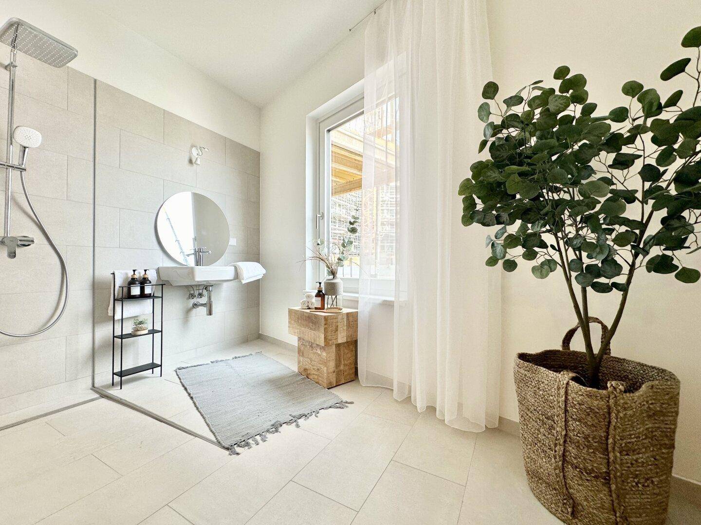 Modernes Badezimmer mit ebenerdiger Dusche, großformatigen Fliesen und einem Fenster für natürliches Licht.