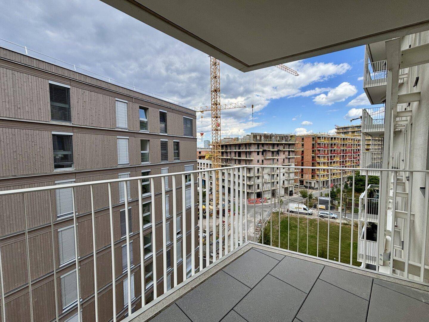 Balkon mit weitem Blick auf die städtische Umgebung und die im Bau befindlichen Nachbargebäude.