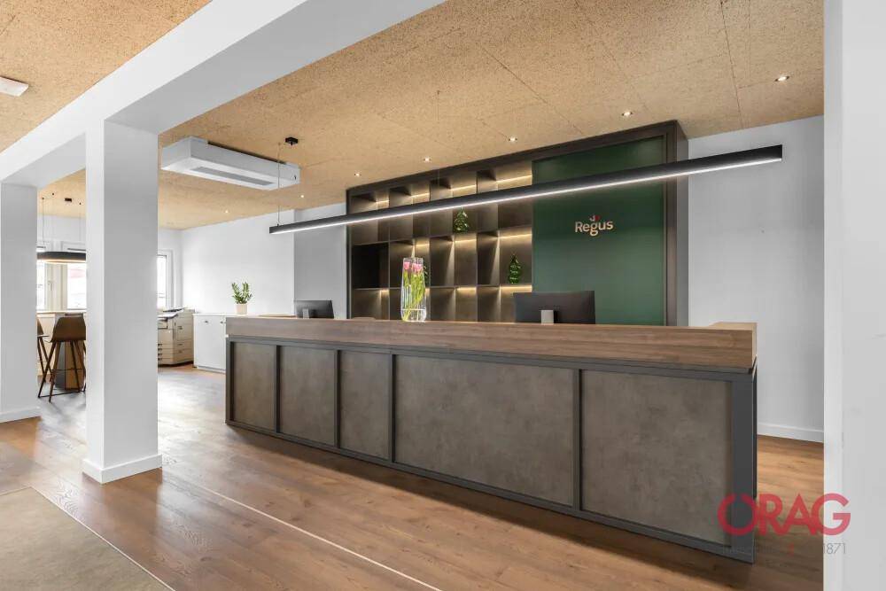 Moderner Empfangsbereich mit Holzboden, stilvoller Theke und dekorativer Wandgestaltung mit Beleuchtung.