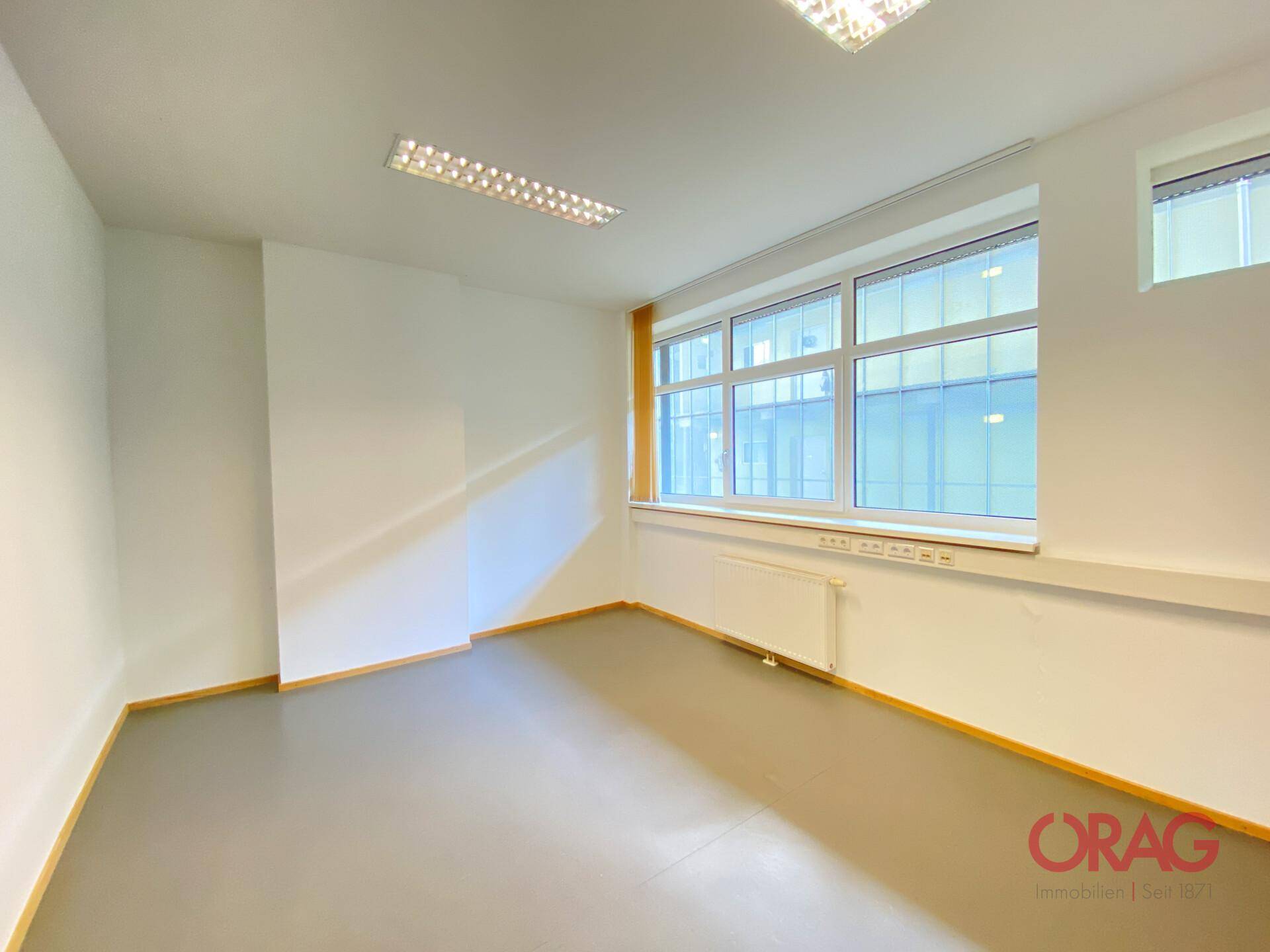 Helles Büro mit großen Fenstern, die viel Licht hereinlassen, und einem schlichten, funktionalen Design.