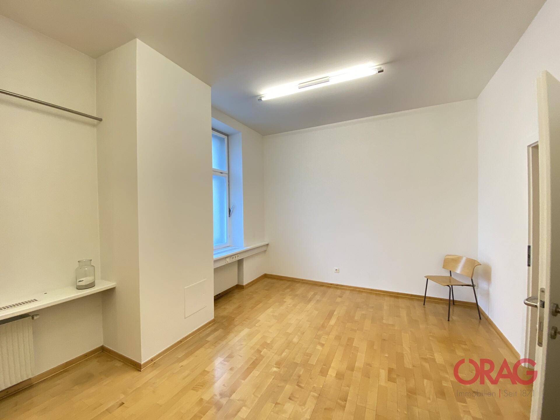 Leerer Raum mit Holzfußboden und einem Fenster, bereit zur individuellen Gestaltung.