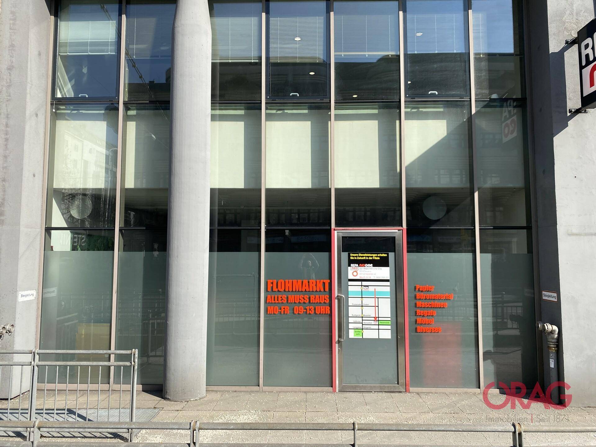 Moderne Geschäftsfassade mit großen Glasfenstern und einer Eingangstür.