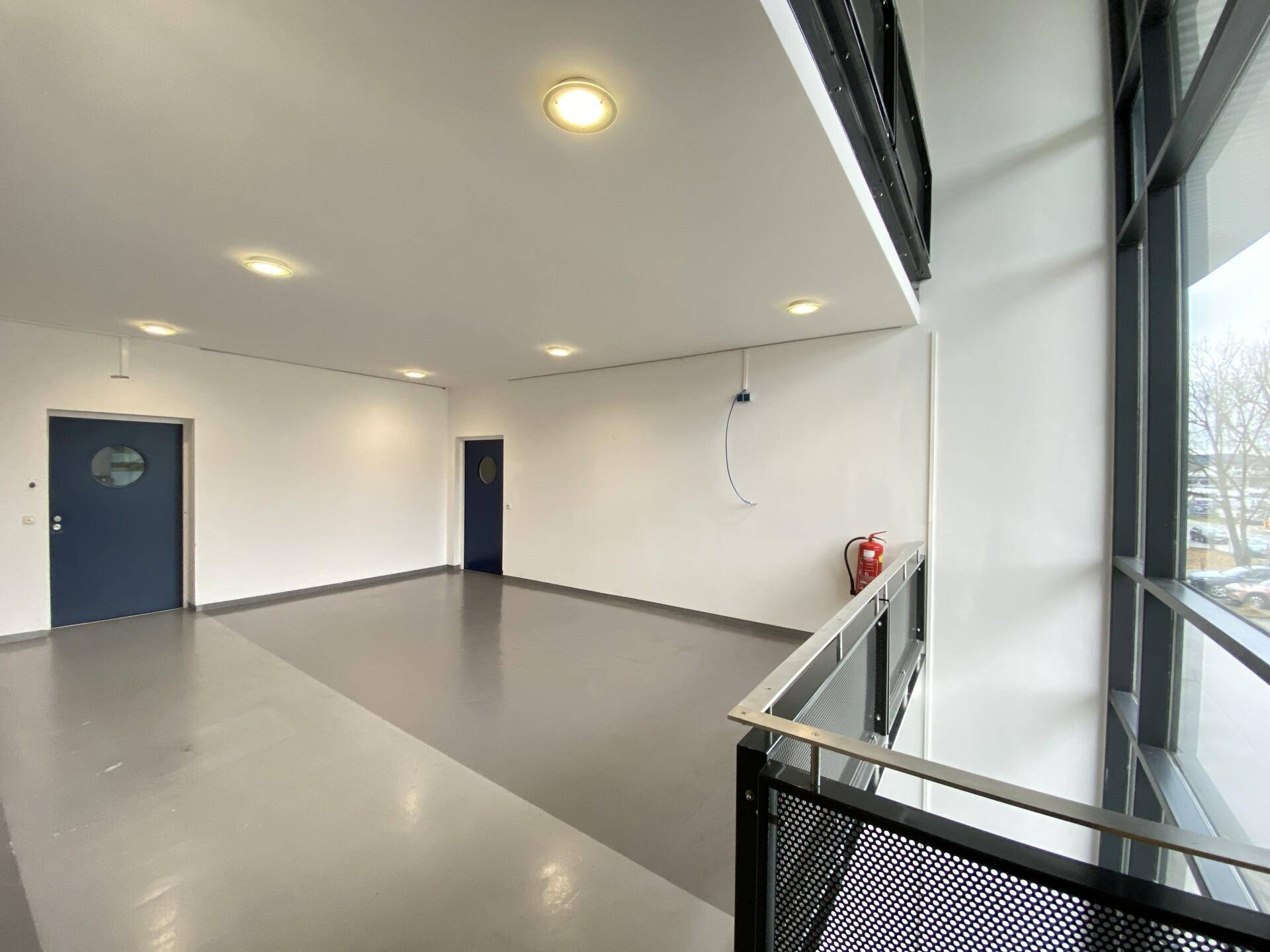 Heller Empfangsbereich mit großen Fenstern und modernen Türen, der viel Tageslicht bietet.