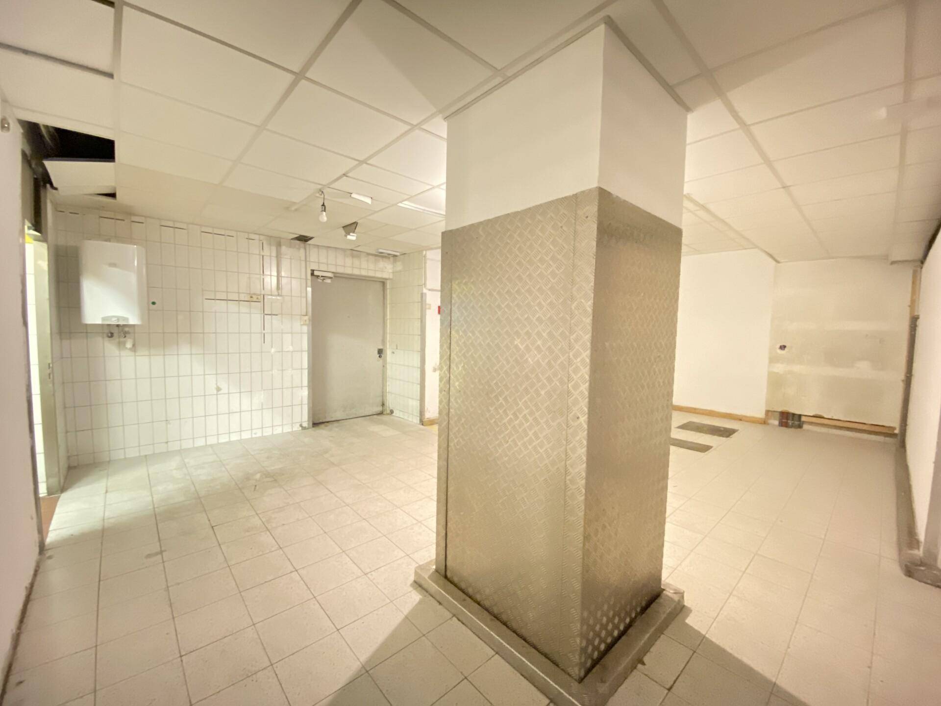 Kellerraum mit Fliesenboden, gefliesten Wänden und einem Warmwasserbereiter, geeignet für Lagerung.