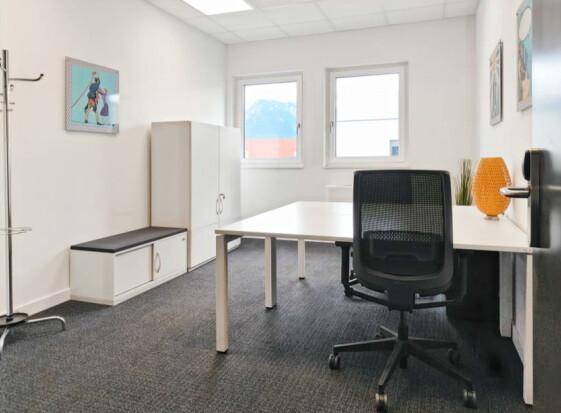 Funktionales Büro mit einem Schreibtisch, Stauraum und Fenstern für natürliches Licht.