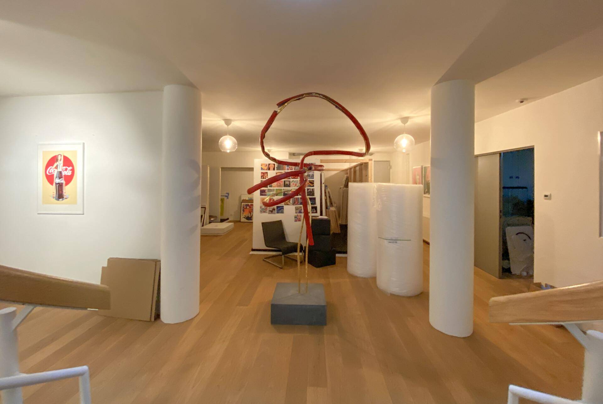 Lagerraum der Galerie mit Skulptur, Verpackungsmaterialien und weiteren Kunstwerken im Hintergrund.