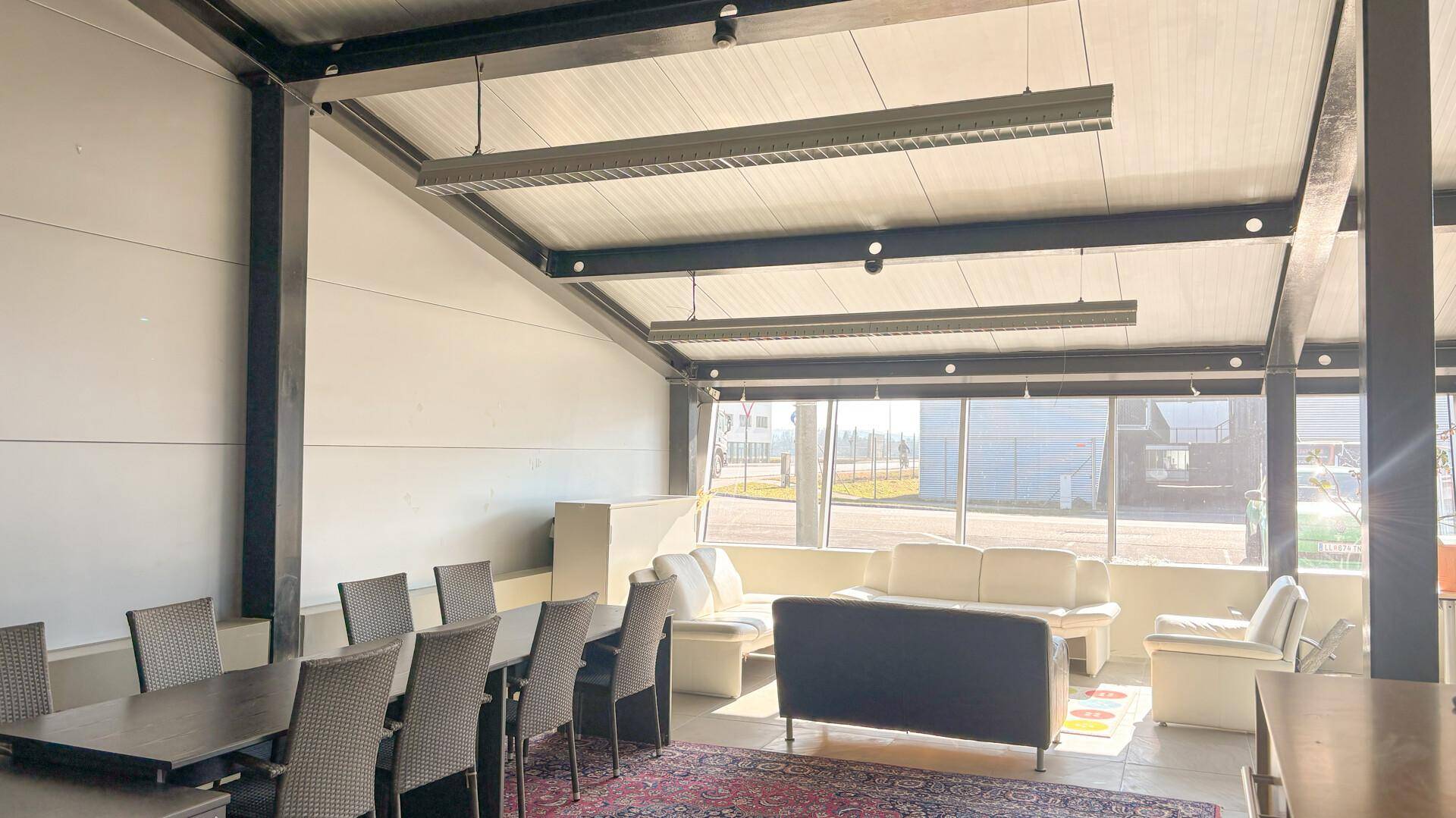 Geräumiger Loungebereich mit bequemen Sofas, Esstisch und großen Fenstern mit weitem Ausblick.