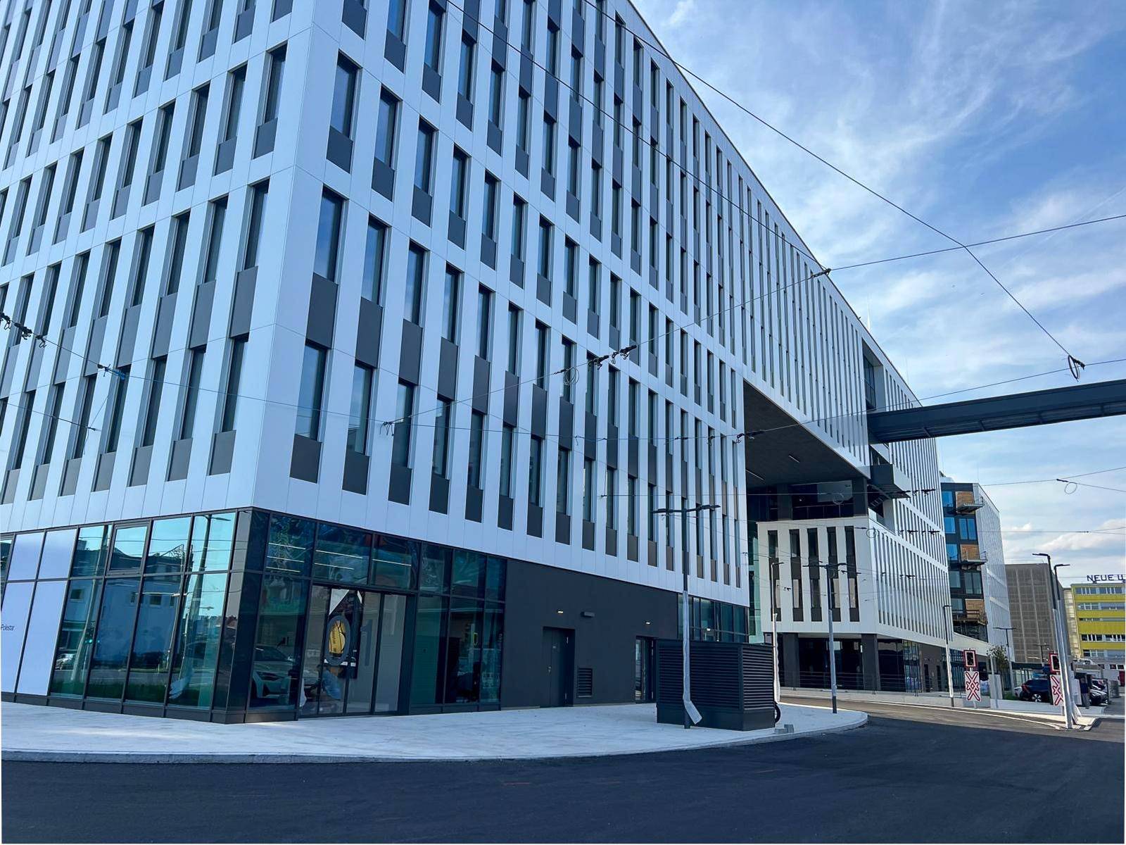 Die beeindruckende Fassade eines modernen Bürokomplexes mit großen Fenstern und klaren Linien.