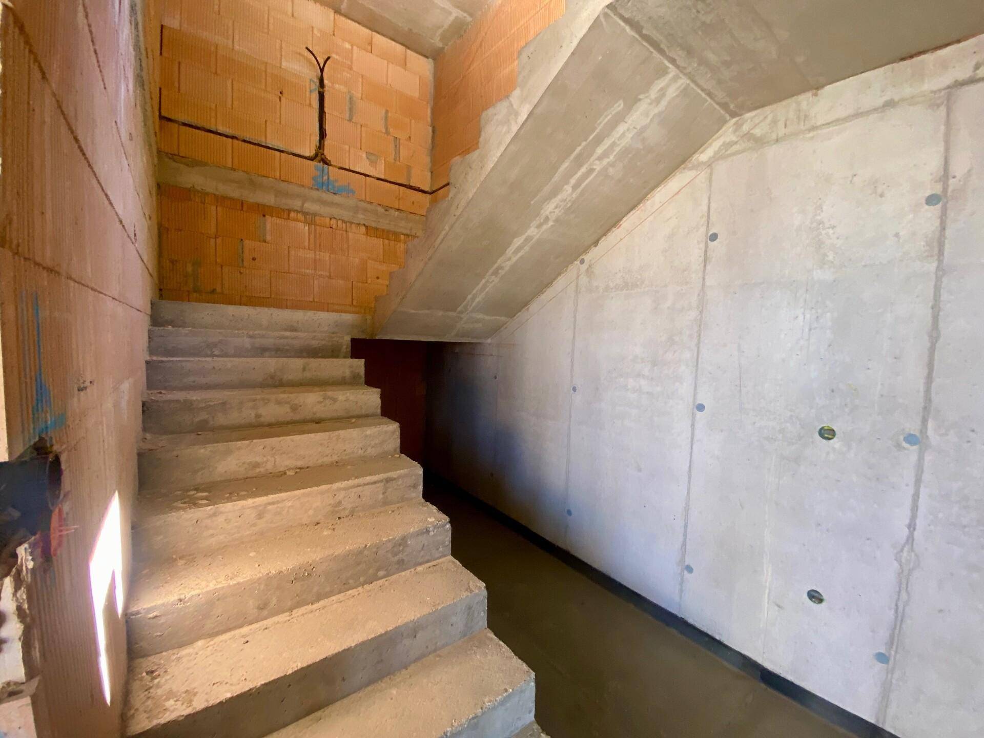 Betonierte Treppe im Inneren des im Bau befindlichen Hauses.