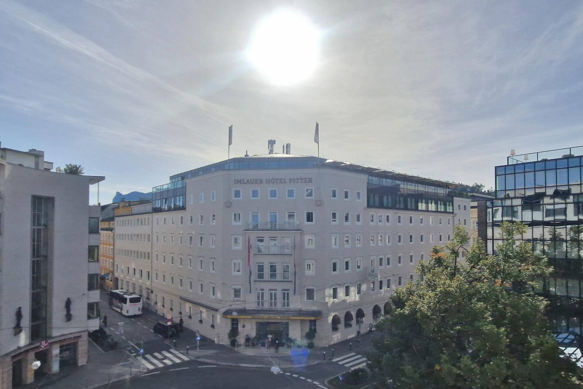 Ansicht eines großen Eckgebäudes mit vielen Fenstern und einem Hotelnamen an der Fassade.