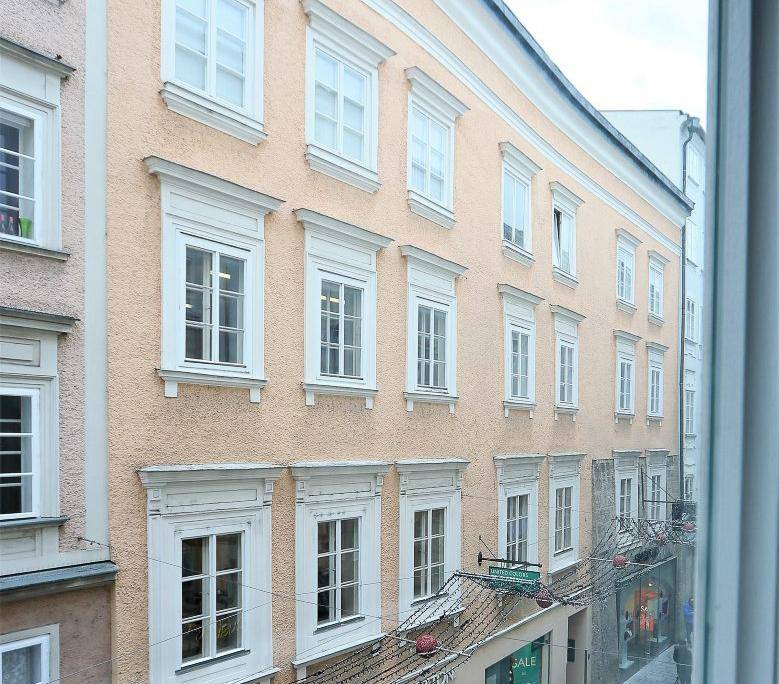 Historische Fassade eines Gebäudes mit vielen Fenstern und traditionellen Verzierungen.