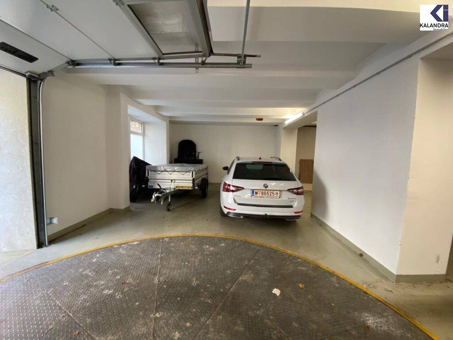 Tiefgarage mit Parkplätzen und einem Auto auf einer Drehscheibe.