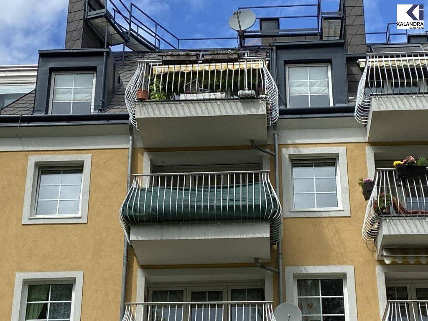 Fassade eines Gebäudes mit mehreren Balkonen und Fenstern.
