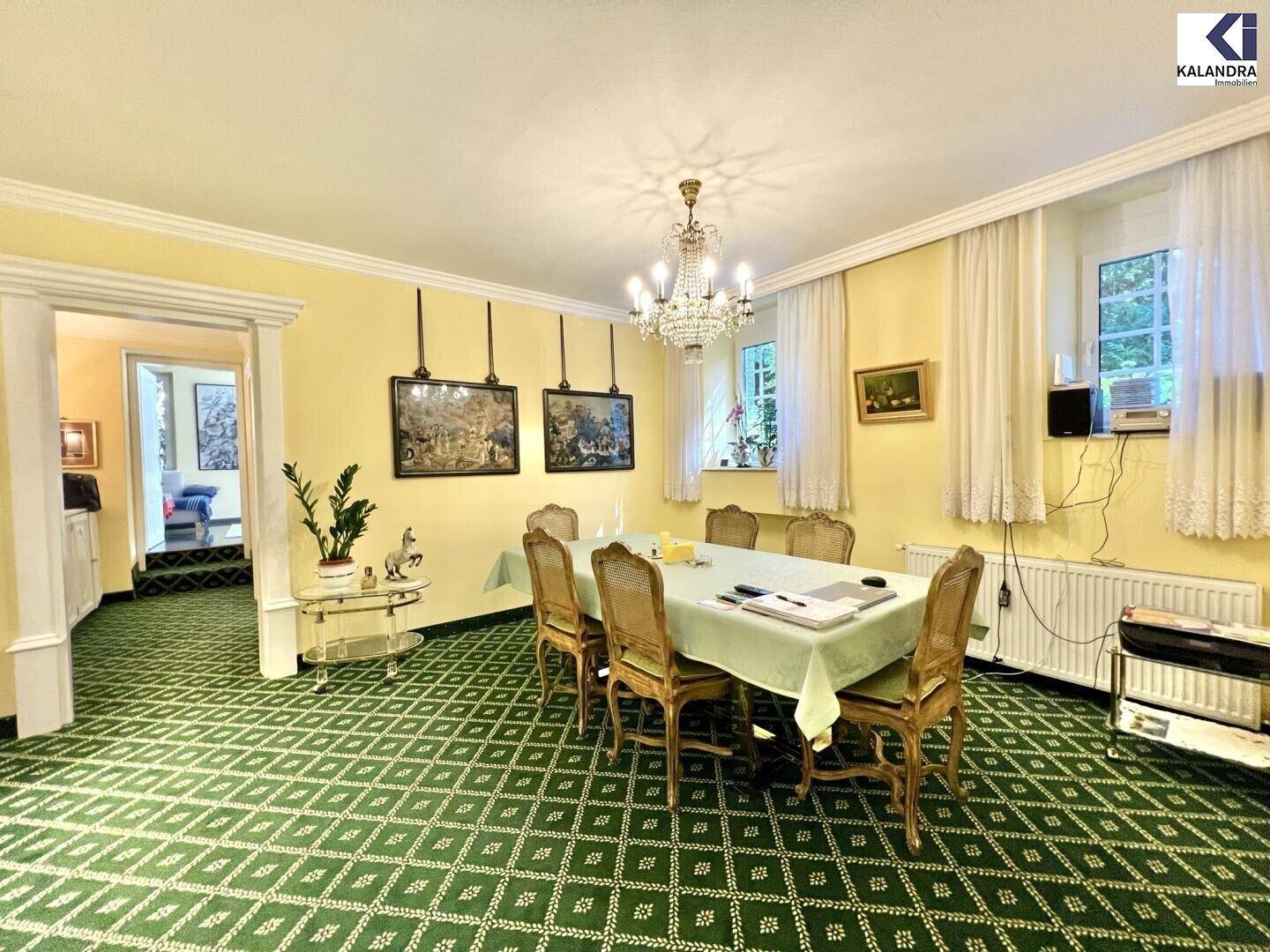 Klassisches Esszimmer mit gelben Wänden, Kronleuchter und einem großen Esstisch für Gäste.