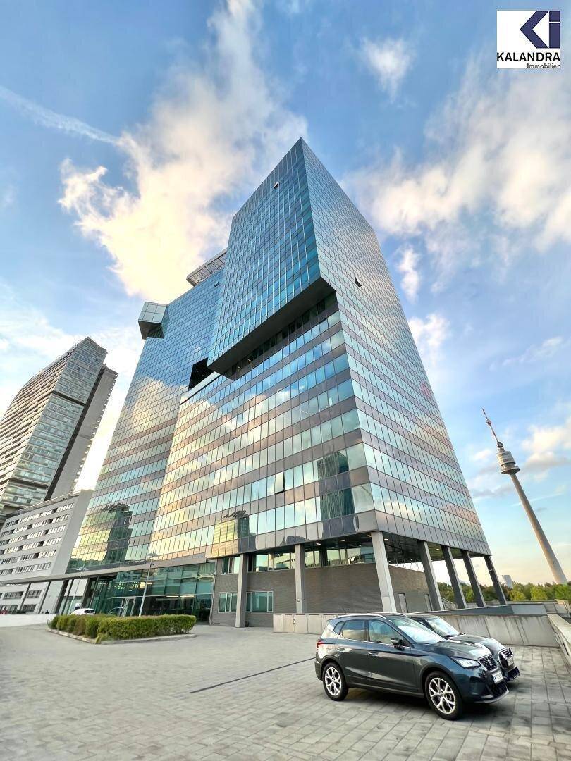 Beeindruckendes modernes Hochhaus mit Glasfassade und einem markanten architektonischen Design unter blauem Himmel.