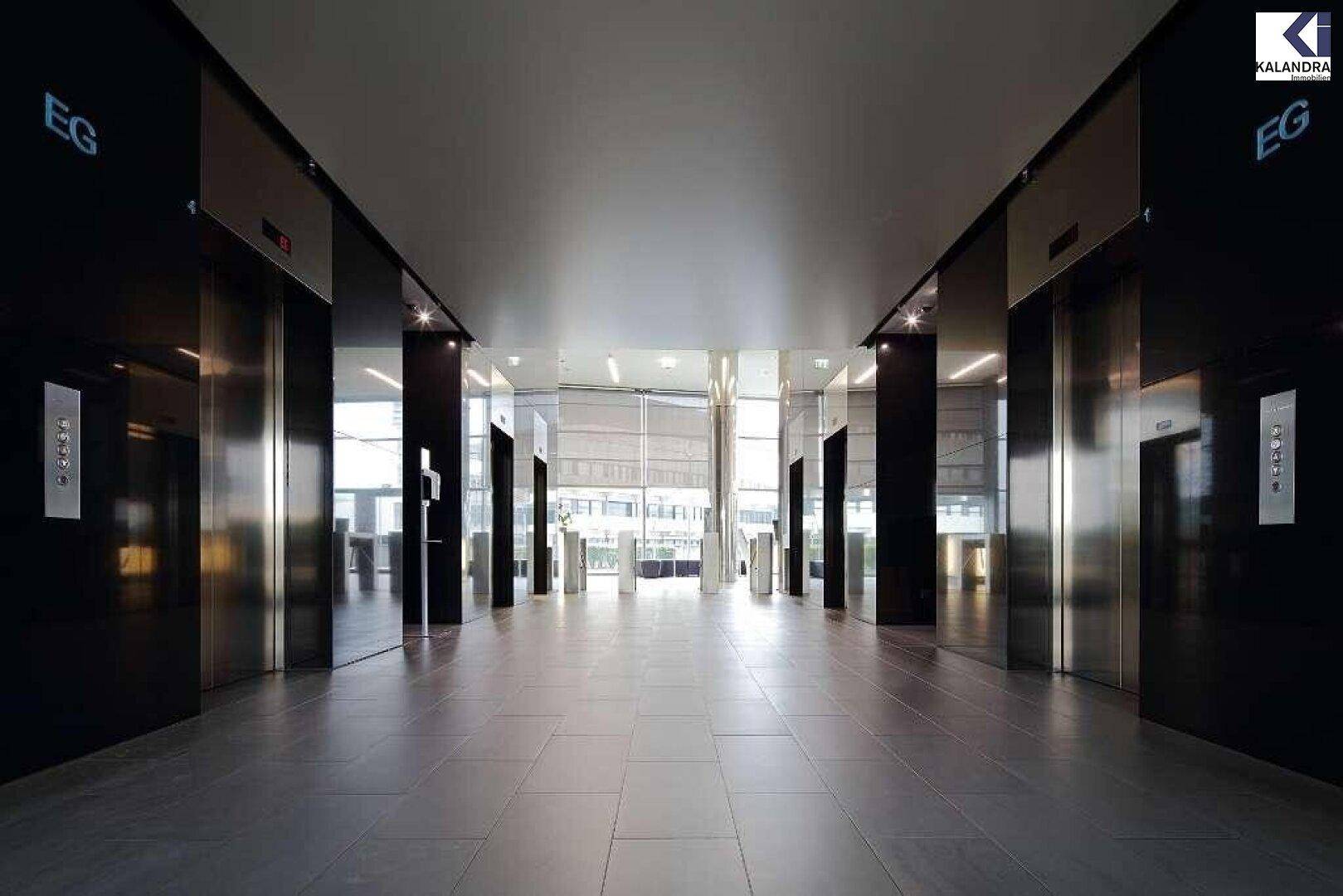 Elegante Lobby mit mehreren Aufzügen, glänzendem Fliesenboden und moderner Beleuchtung.