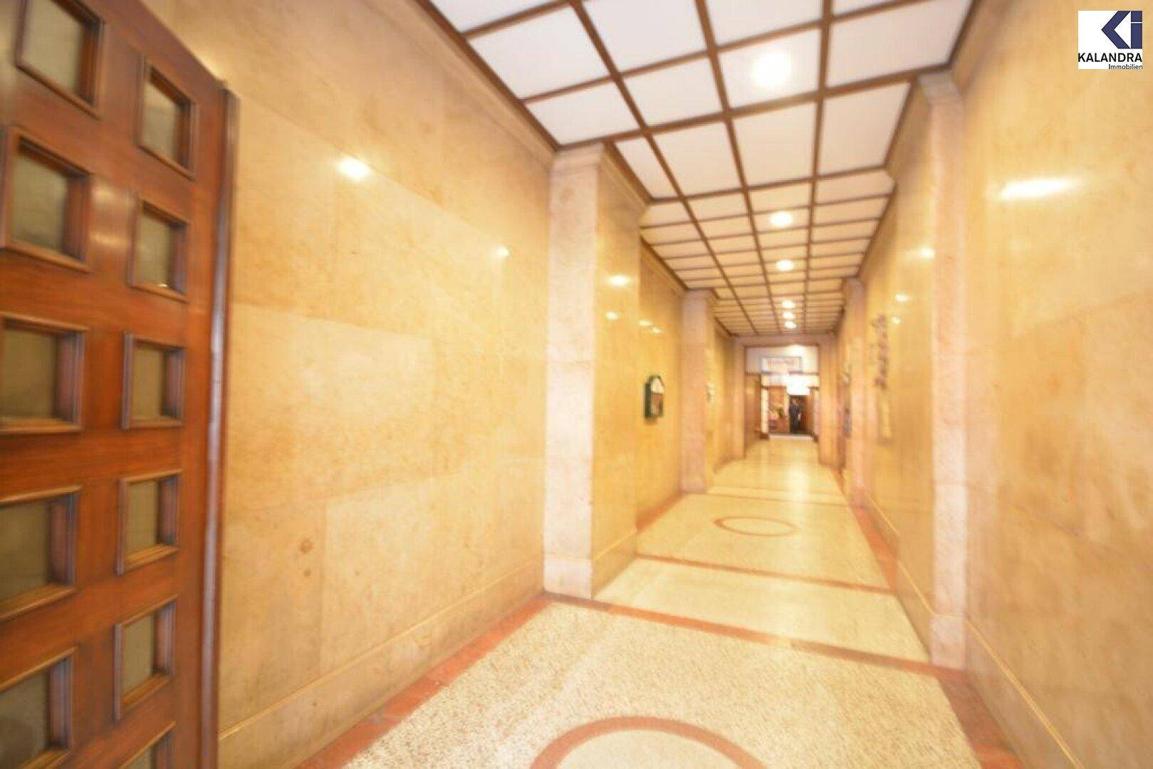 Eleganter Flur mit Marmorwänden und gemustertem Boden, der einen luxuriösen Eingangsbereich bietet.