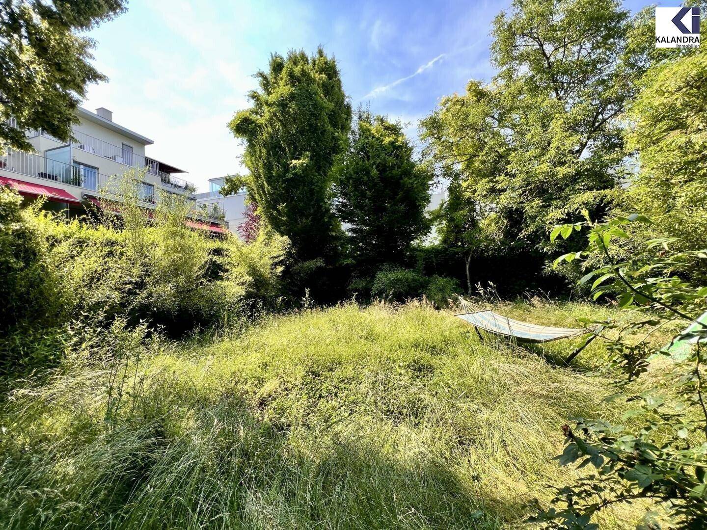 Großer, naturbelassener Garten mit Bäumen, Sträuchern und einer Hängematte.