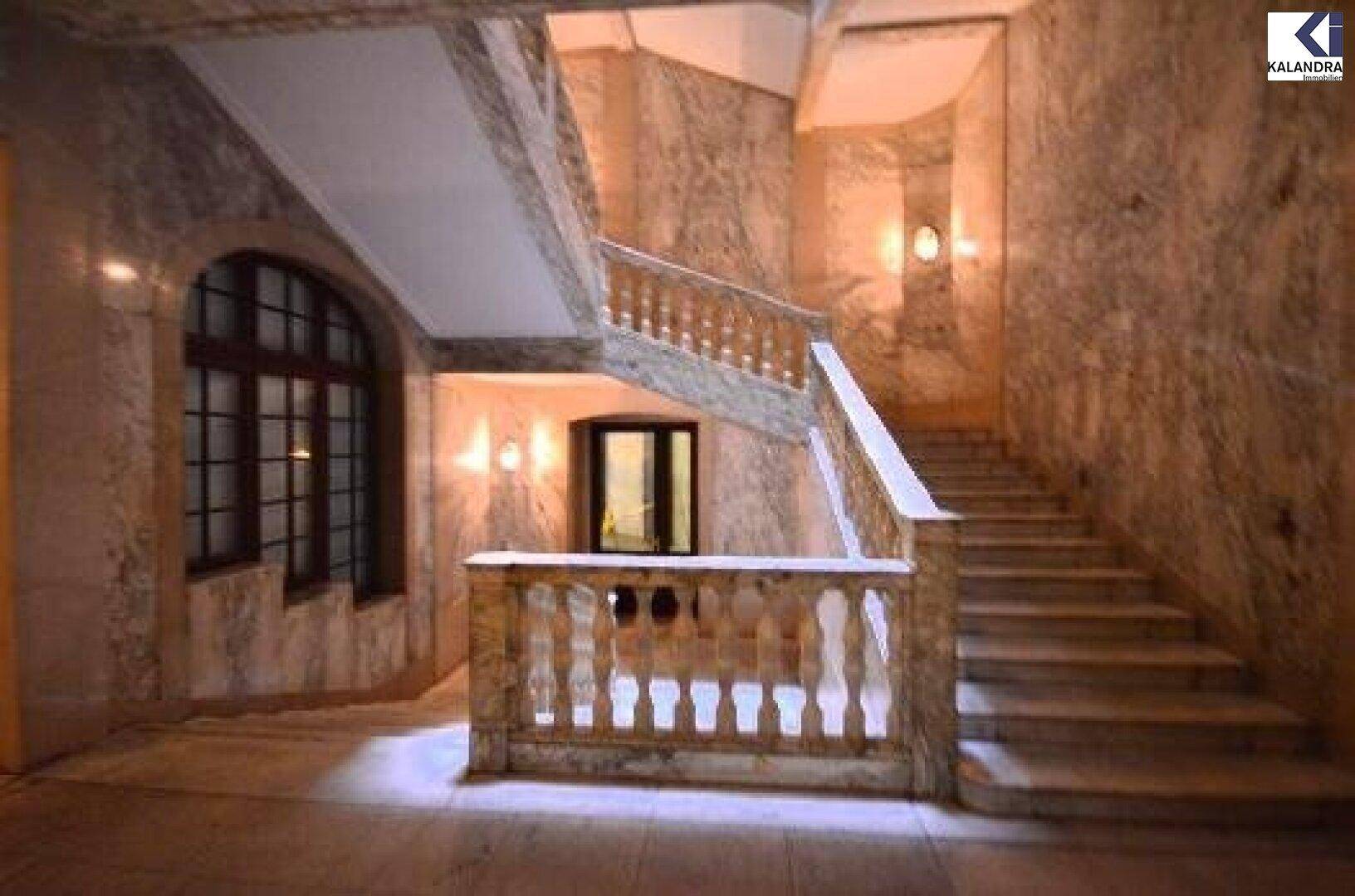 Historisches Treppenhaus mit Marmorverkleidung und kunstvollen Balustraden.