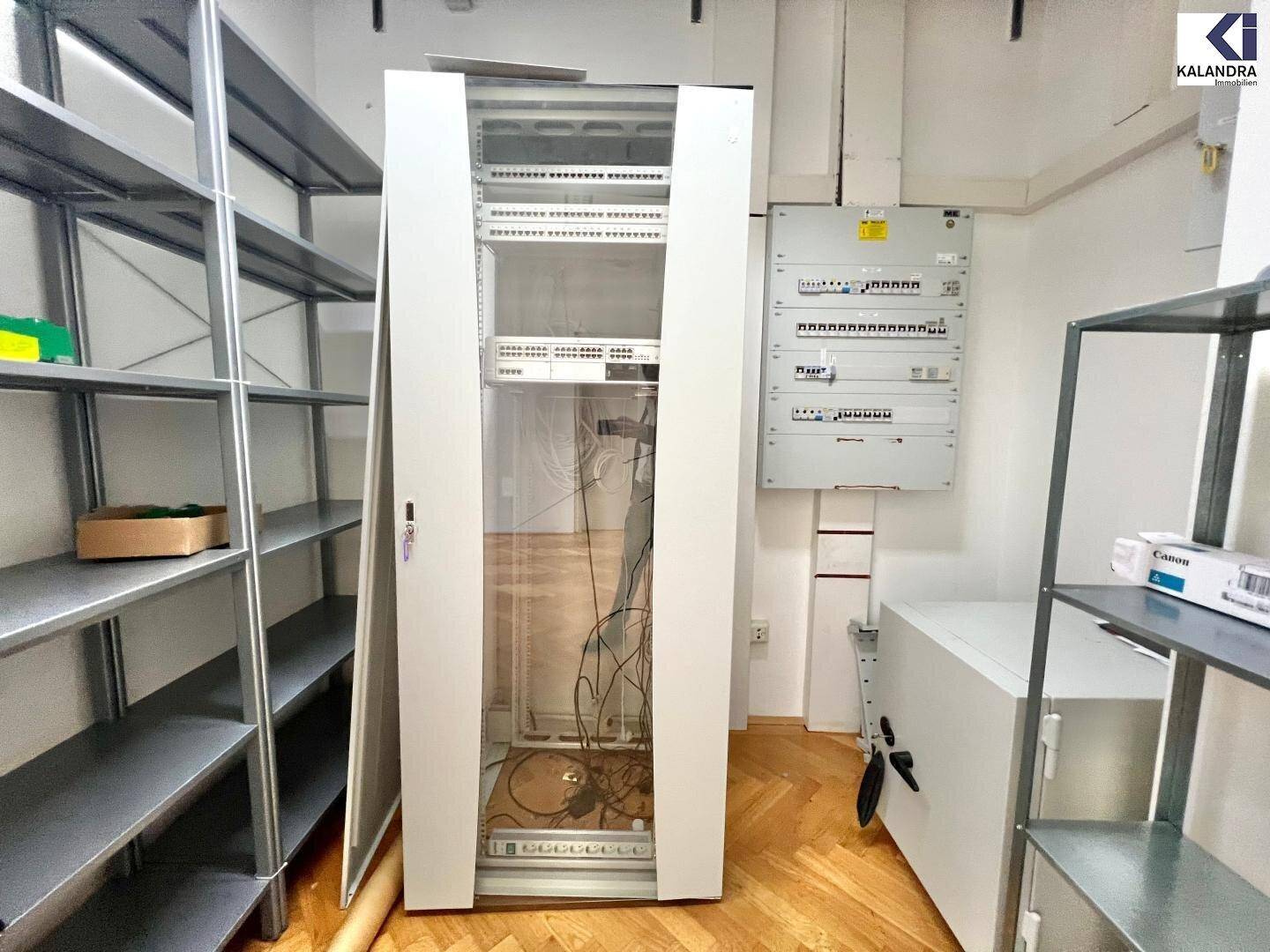 Lagerraum mit Regalen, Serverschrank und elektrischer Verteilung.