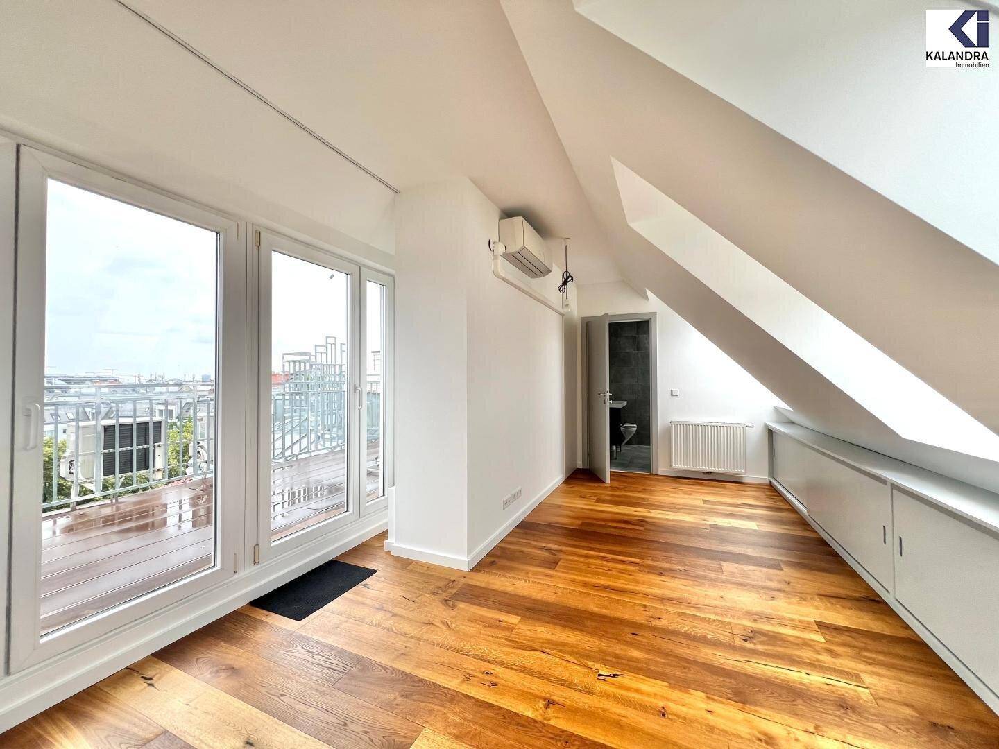 Heller Raum im Dachgeschoss mit Holzboden, Zugang zur Terrasse und praktischen Einbauschränken.