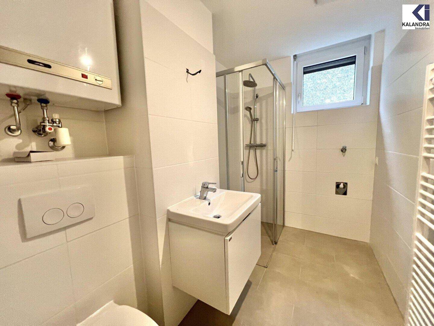 Modernes Badezimmer mit Duschkabine, wandhängendem WC und Handtuchheizkörper.