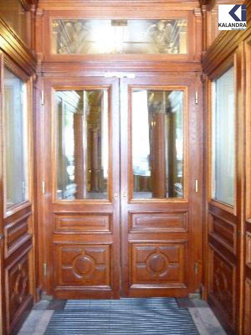 Prächtige Holztüren mit Glaseinsätzen in einem eleganten Eingangsbereich.