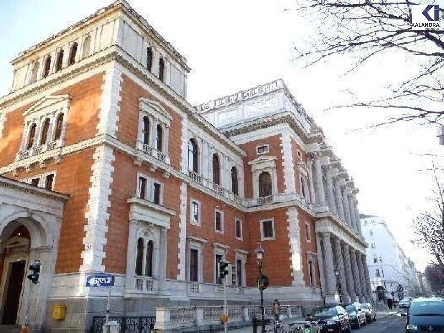 Historisches Gebäude mit beeindruckender Fassade und Säulen, umgeben von städtischer Architektur.