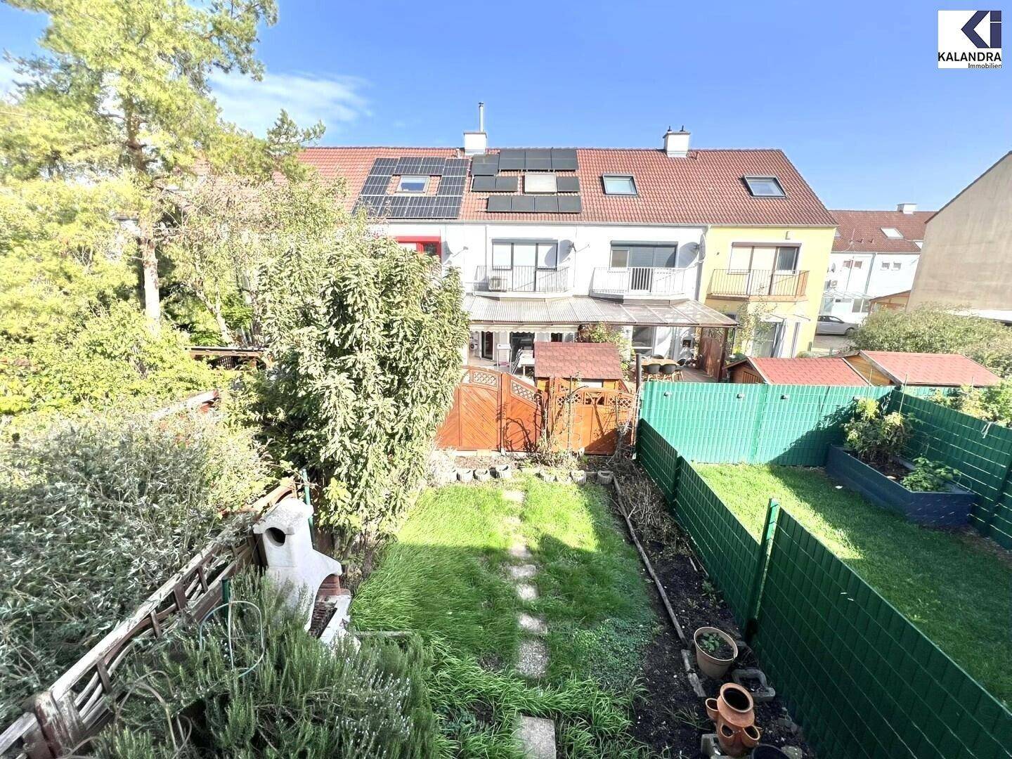 Überblick über die Gärten der Reihenhäuser mit Solaranlagen auf den Dächern.