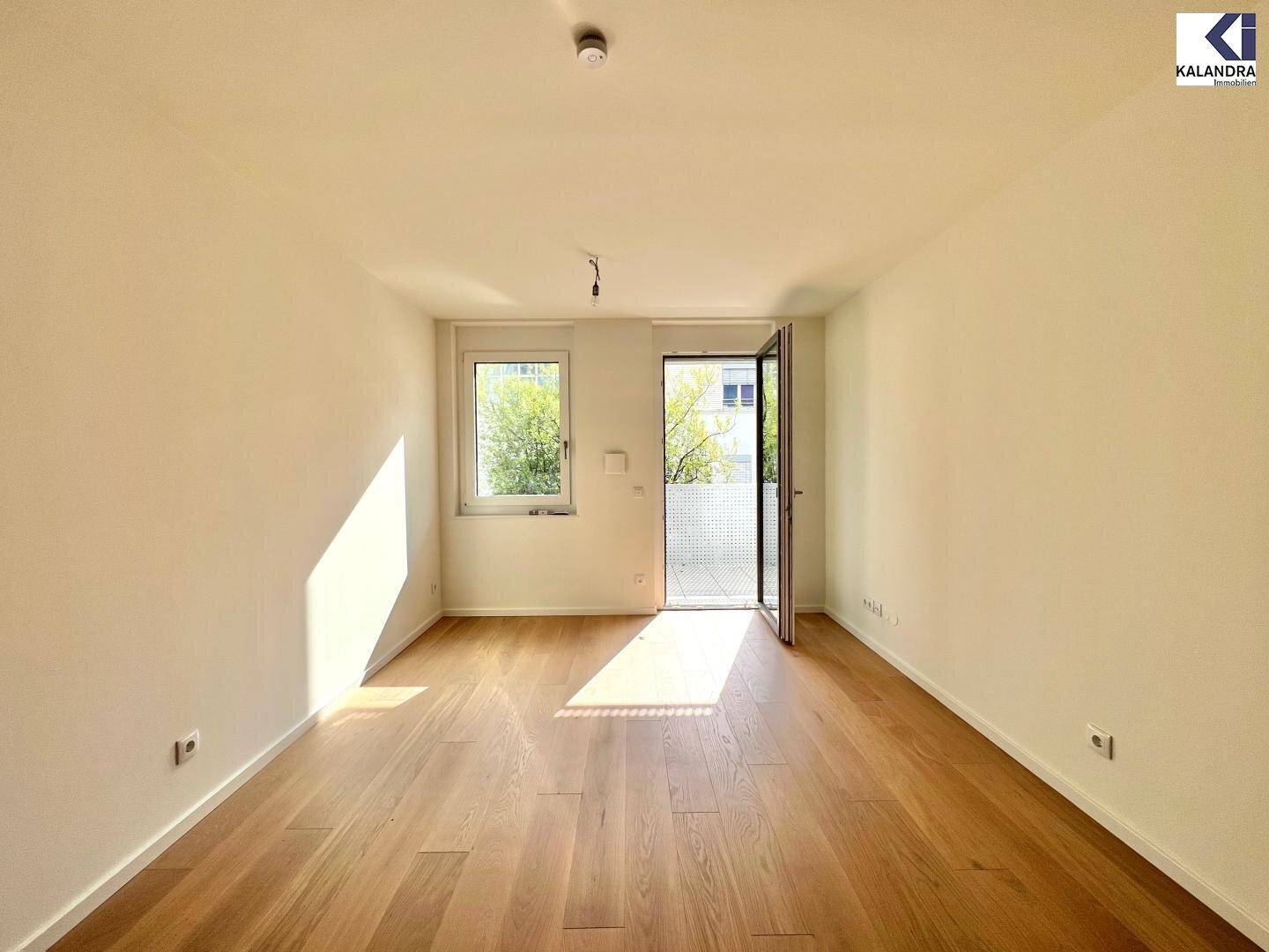 Heller Wohnraum mit Eichenparkett und großen Fenstern, die viel Tageslicht hereinlassen.
